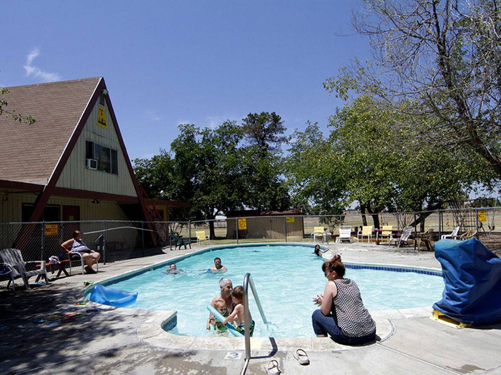 Community swimming pool with children playing at SAC-WEST RV PARK AND CAMPGROUND
