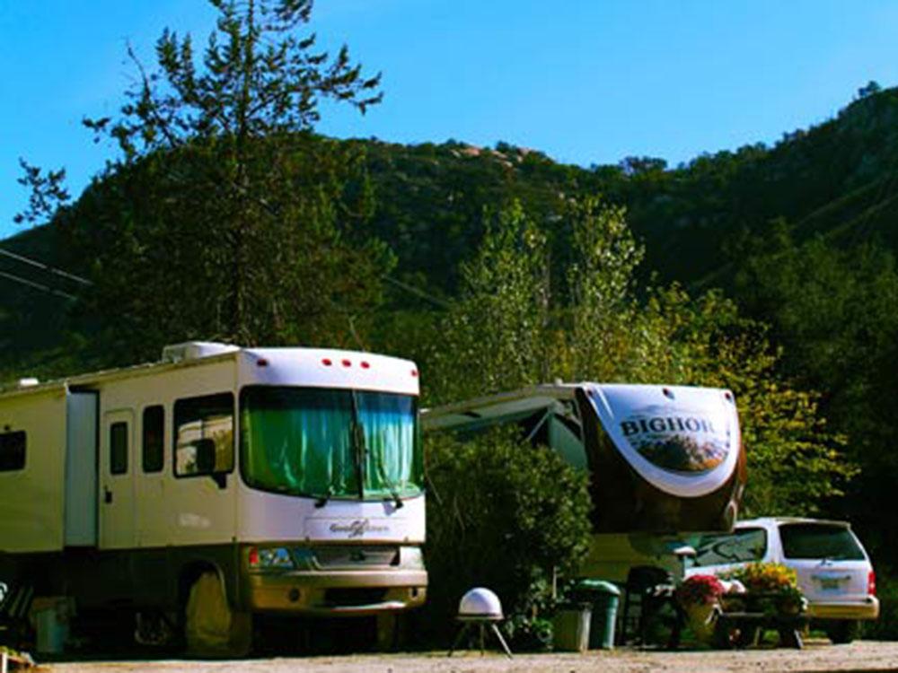 A motorhome and trailer in a RV site at WOODS VALLEY KAMPGROUND & RV PARK