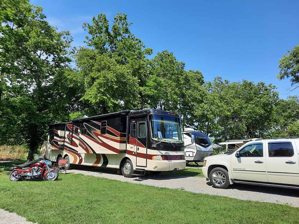 A motorhome and truck in a RV site at ELKHORN CREEK RV PARK