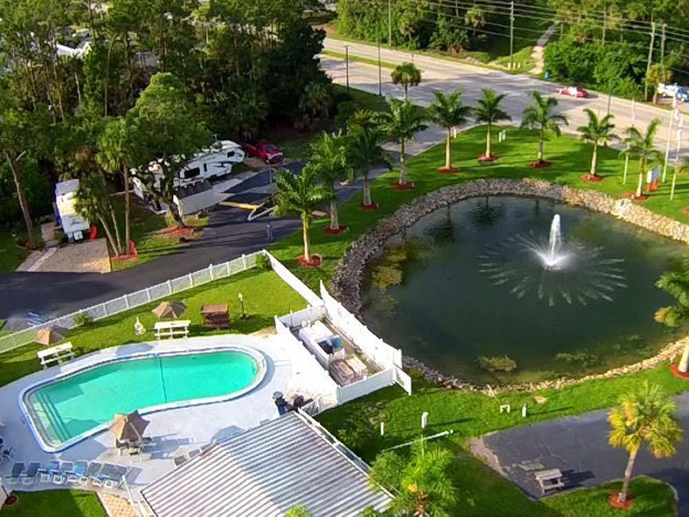 Aerial view of large pond with fountain community pool and lush landscaping at BONITA LAKE RV RESORT