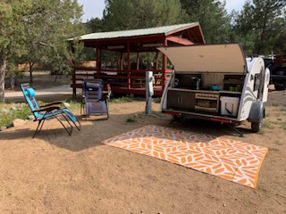 Campsite with outdoor rug and chairs at SUGARBUSH CAMPGROUND