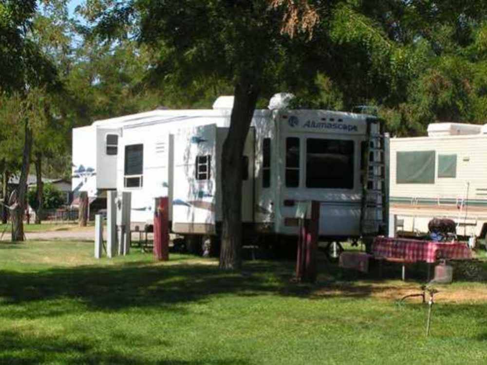A fifth wheel trailer under a tree at HAT ROCK CAMPGROUND
