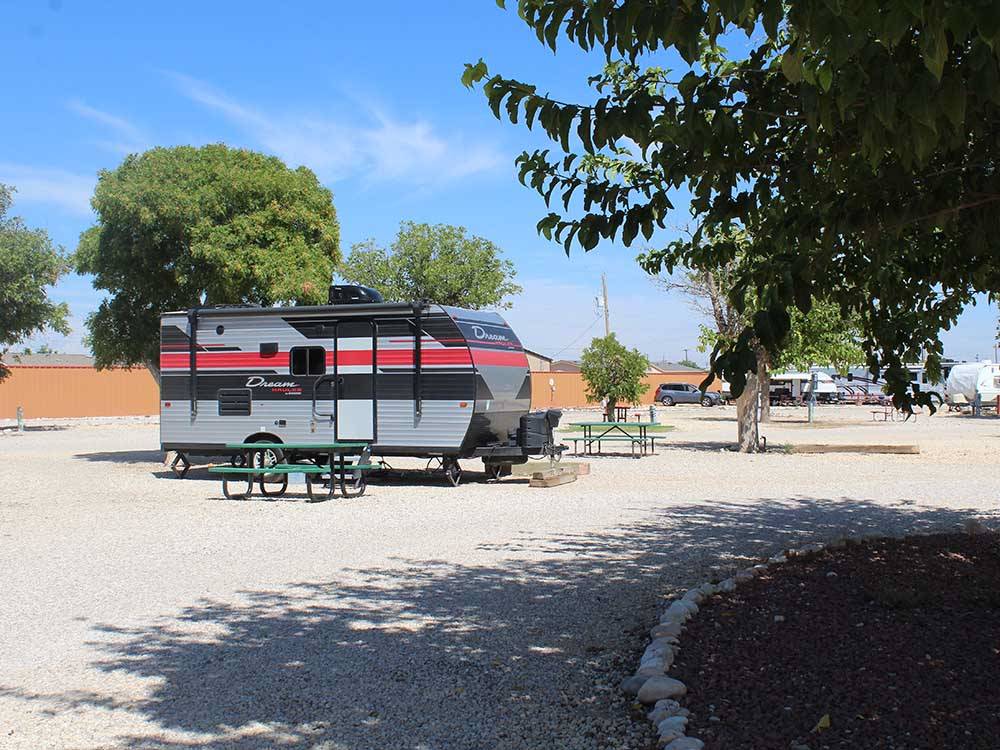 A red and black travel trailer in a RV site at CARLSBAD RV PARK & CAMPGROUND