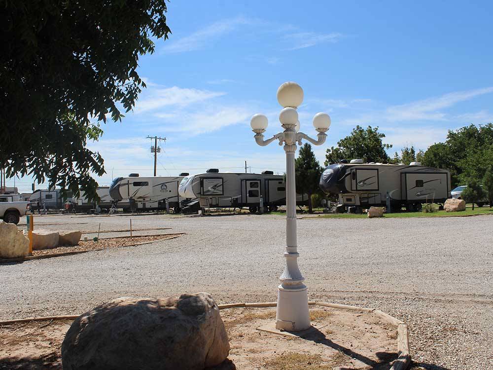 A row of travel trailers parked in gravel sites at CARLSBAD RV PARK & CAMPGROUND