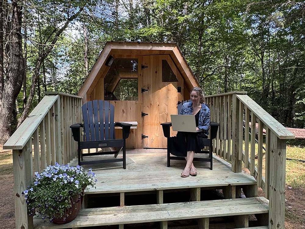 A woman sitting on the porch of her rental cabin