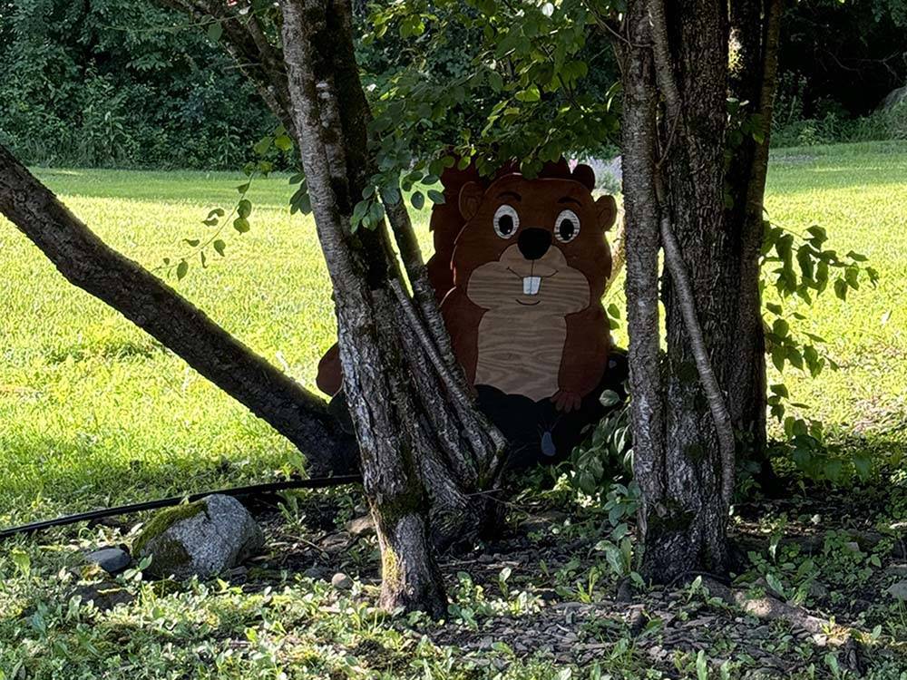 A large squirrel made of wood under a tree