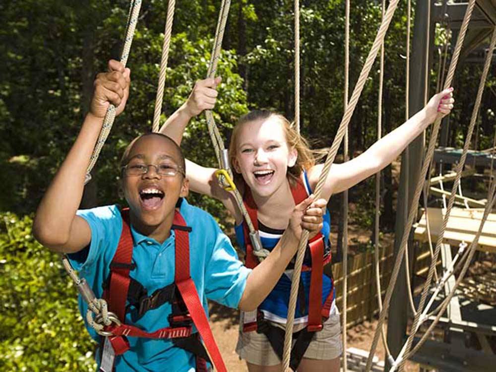 Two kids walking across a rope at STONE MOUNTAIN PARK CAMPGROUND