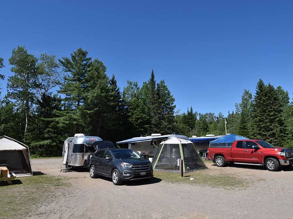 Row of RVs parked on-site at STILLWATER TENT & RV PARK