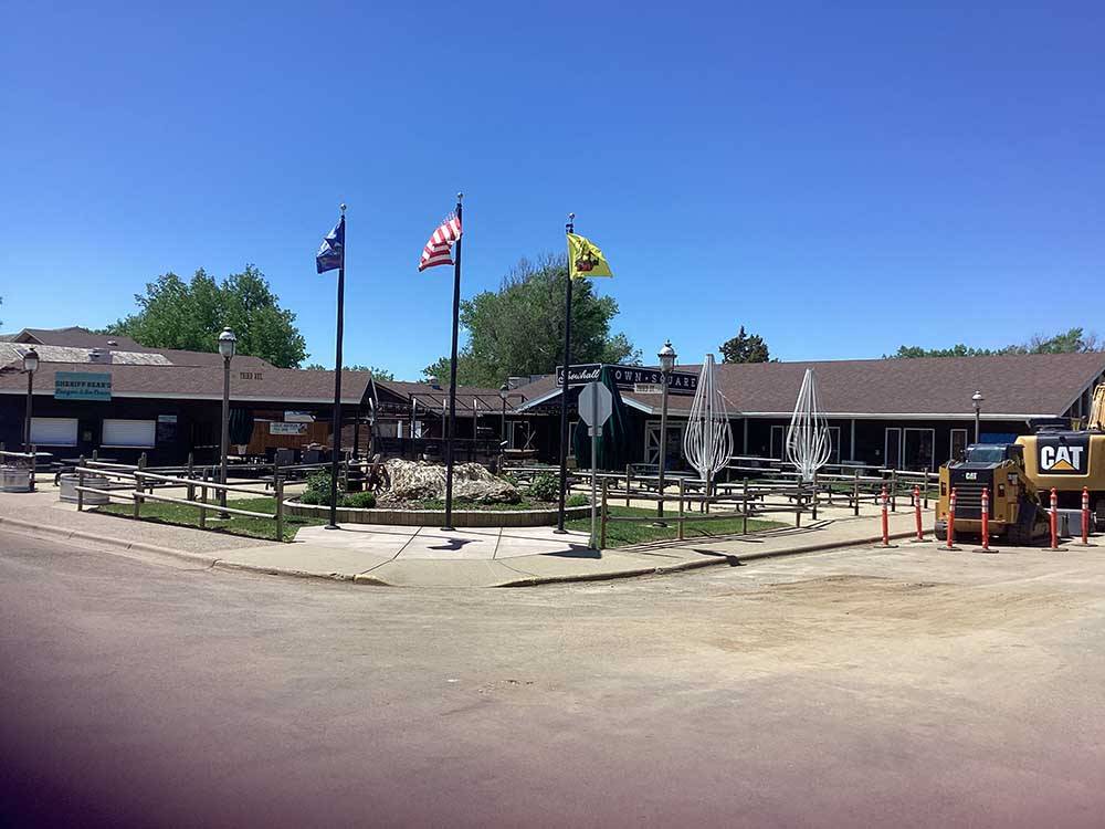 Three flags in front of Showhall Town Square at RED TRAIL CAMPGROUND