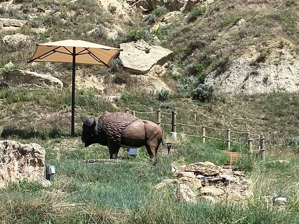 A buffalo statue on the mountain under an umbrella at RED TRAIL CAMPGROUND