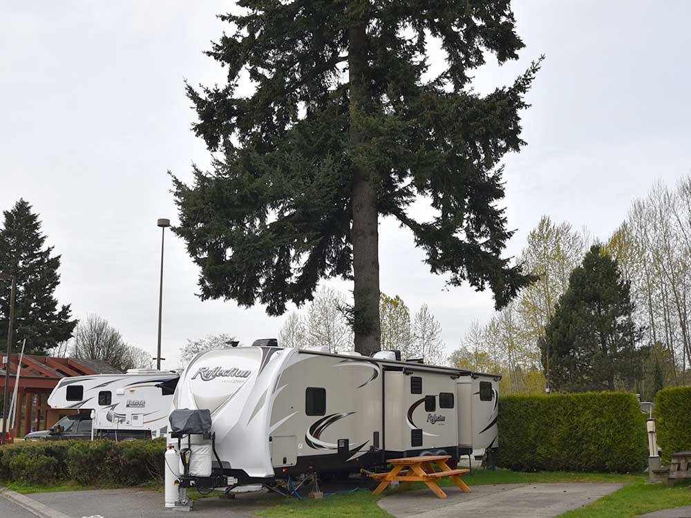 A travel trailer in a back in RV site at CAPILANO RIVER RV PARK