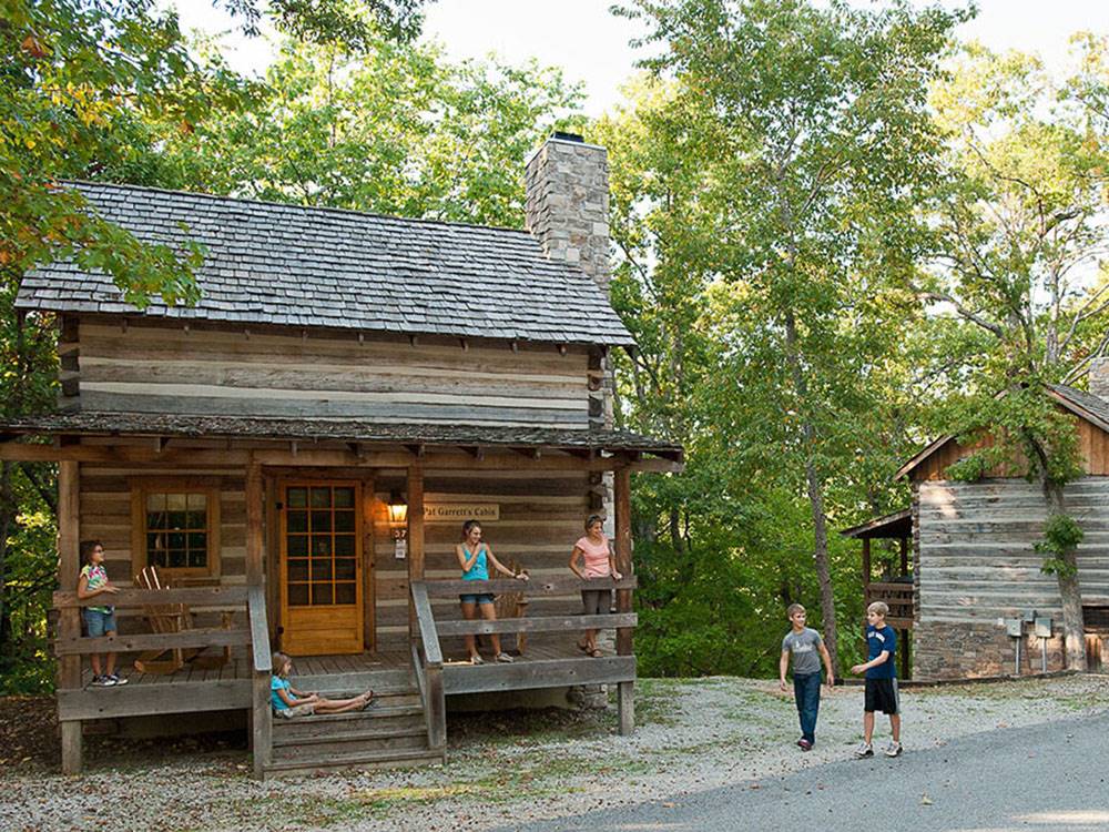 People on the porch of a rustic cabin