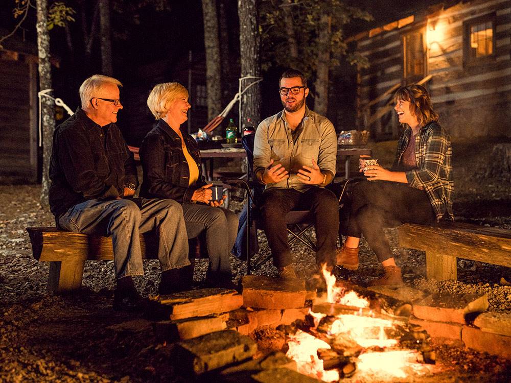 Two couples sitting by the fire at night