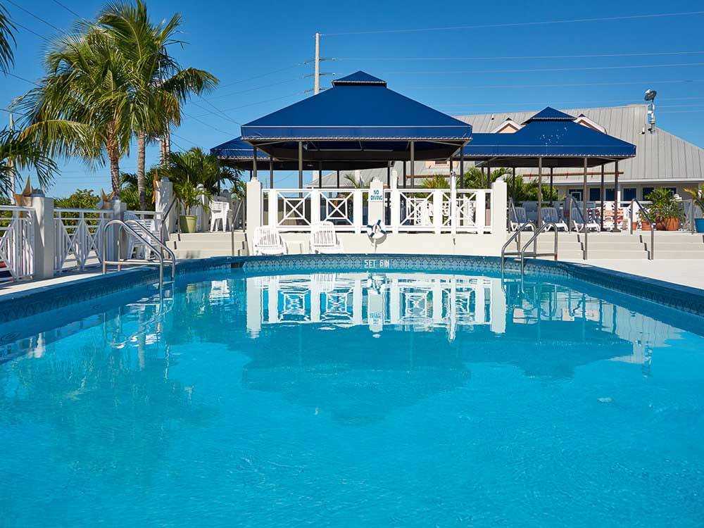 The aquamarine waters of a pool reflect a covered patio at BIG PINE KEY RESORT