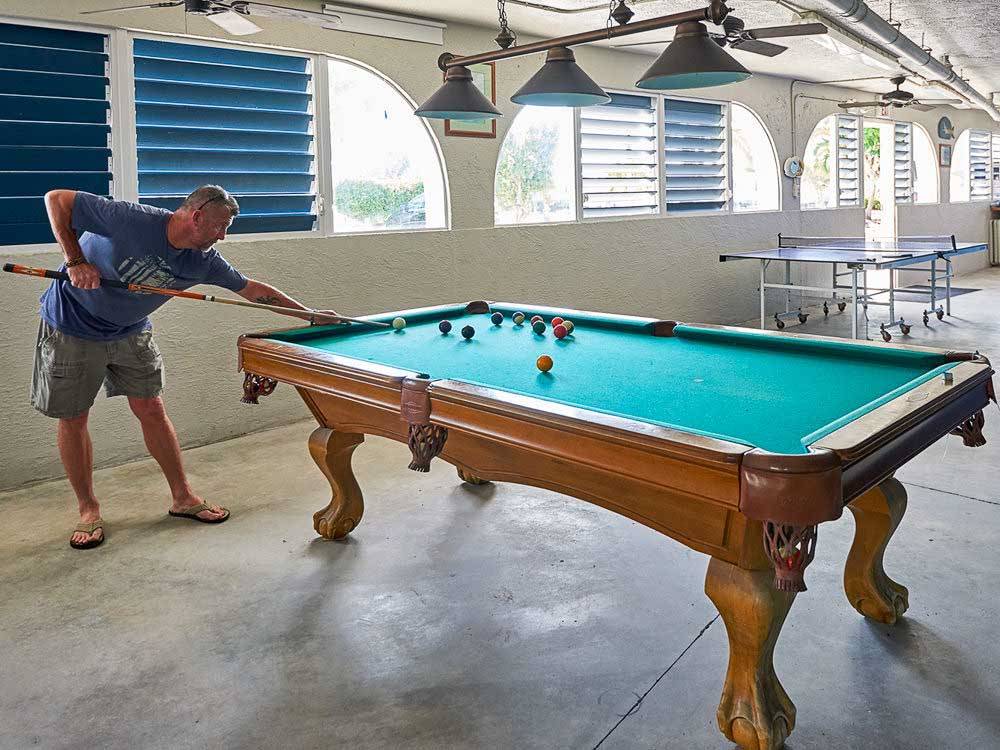 Man playing pool in rec room at BIG PINE KEY RESORT