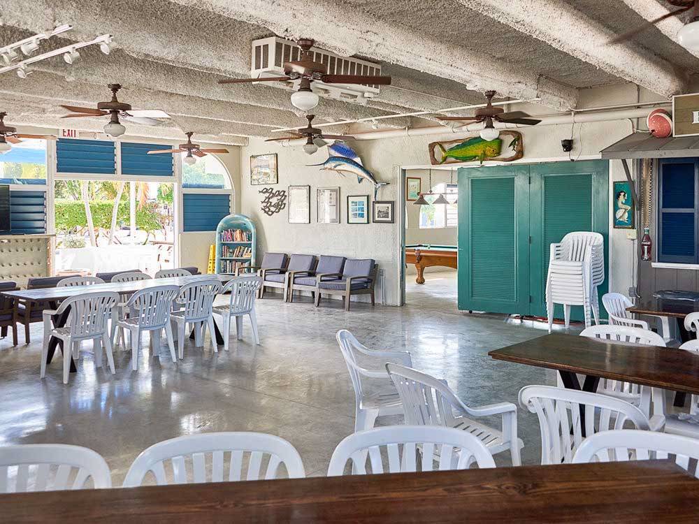 White chairs pulled up to tables under ceiling fans at BIG PINE KEY RESORT