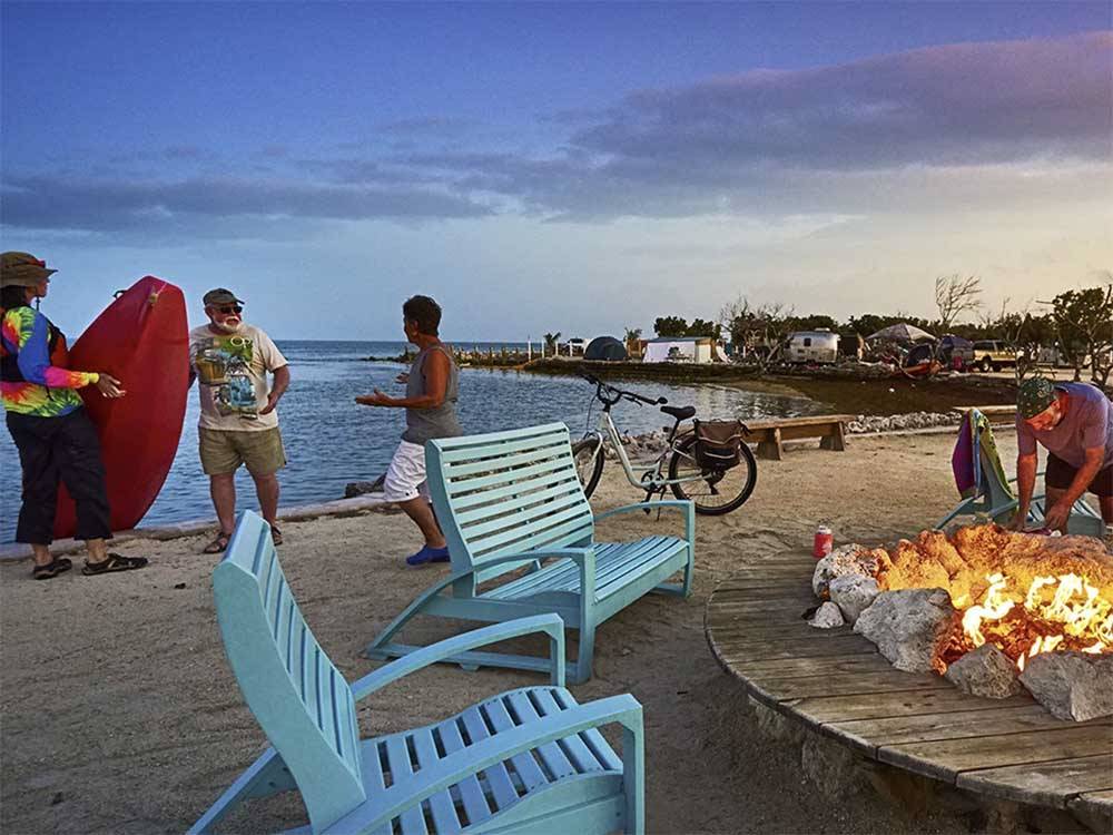 People on the beach next to a large fire pit at BIG PINE KEY RESORT