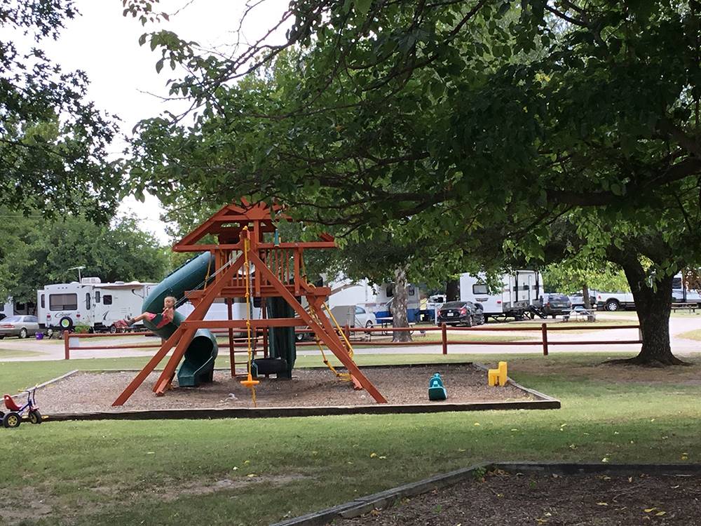 Child on a swing at a playground at DALLAS NE CAMPGROUND