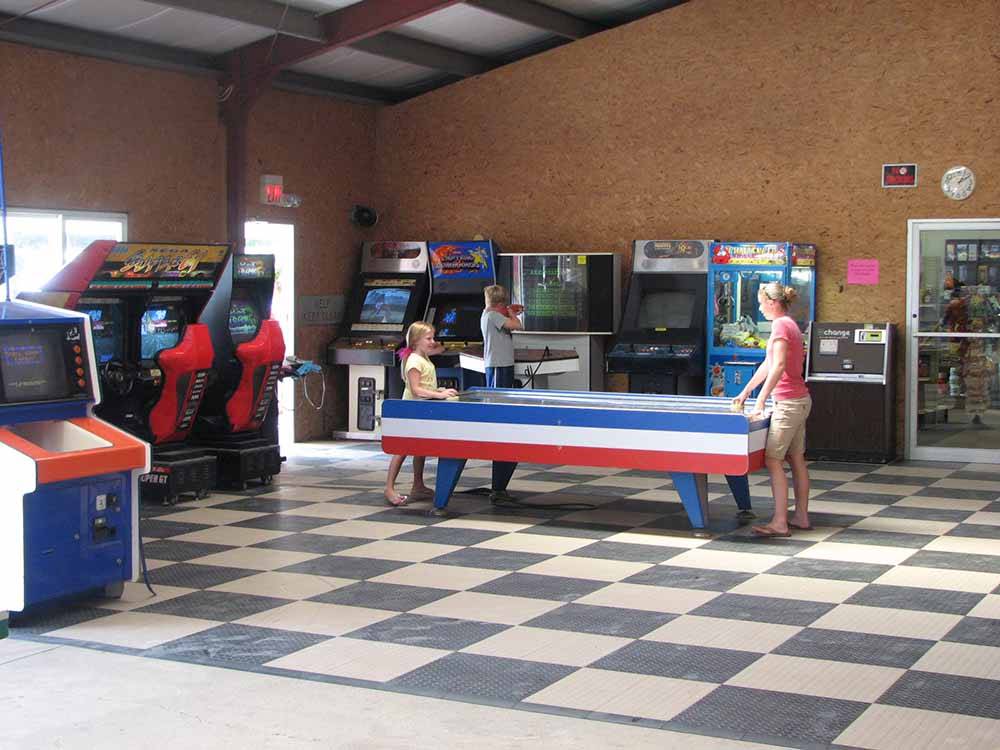 Kids playing air hockey in the arcade at ACORN CAMPGROUND