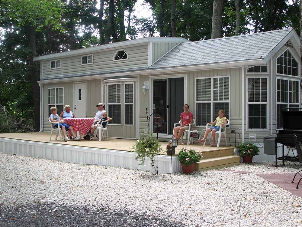 People sitting next to one of the rental houses at ACORN CAMPGROUND