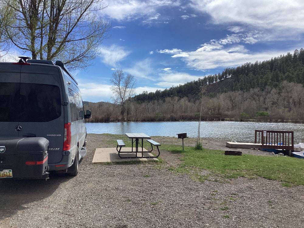 Van parked next to picnic table on the waterfront at Pagosa Riverside Campground