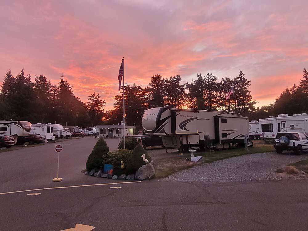 RVs parked in sites against a beautiful sunset at Port Orford RV Village