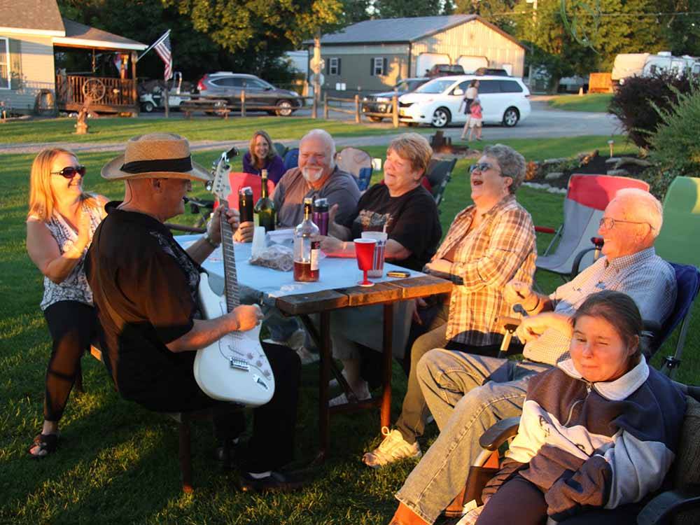A group of people listening to a guitar at THE "WILLOWS" ON THE LAKE RV PARK & RESORT