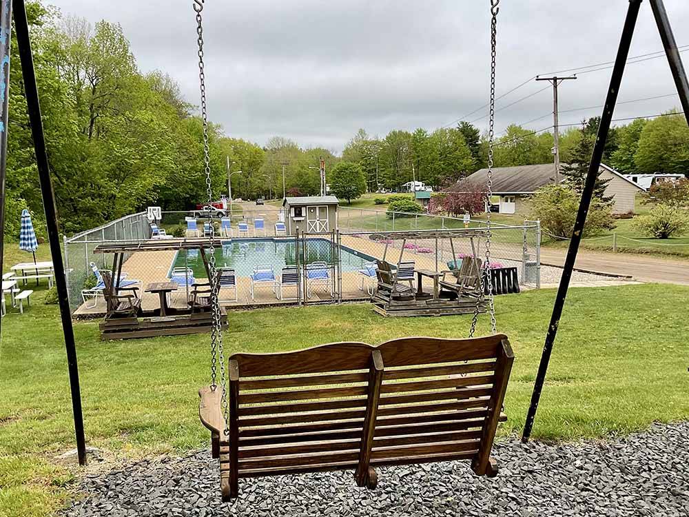 A swing overlooking the swimming pool at OAK HAVEN FAMILY CAMPGROUND