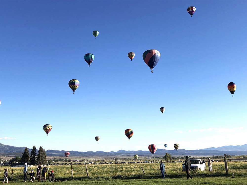 People looking at the hot air balloons at DIXIE FOREST RV RESORT BY RJOURNEY