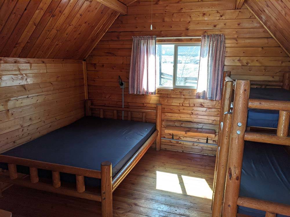 The beds inside of the cabin at DIXIE FOREST RV RESORT BY RJOURNEY