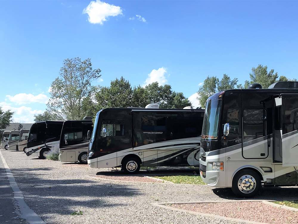 A row of motorhomes in gravel sites at CEDAR CITY RV RESORT BY RJOURNEY