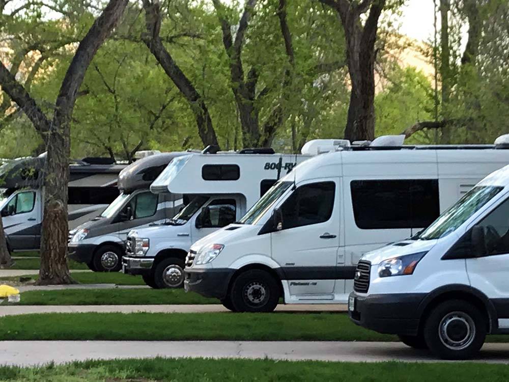 A row of motorhomes in paved sites at CEDAR CITY RV RESORT BY RJOURNEY