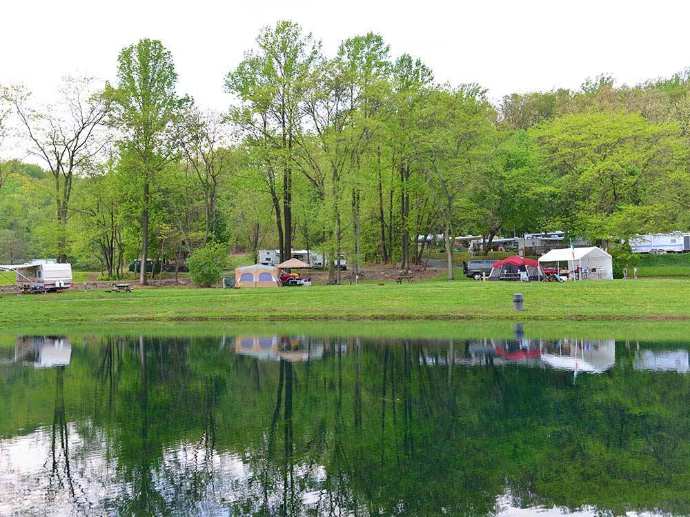 Tents and trailers on green grass near lake at SPRING GULCH RESORT CAMPGROUND