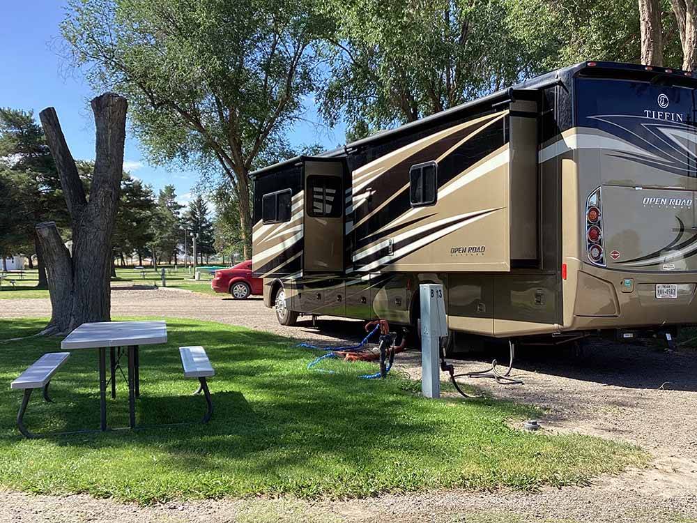 A motorhome in a gravel pull thru RV site at VILLAGE OF TREES RV RESORT
