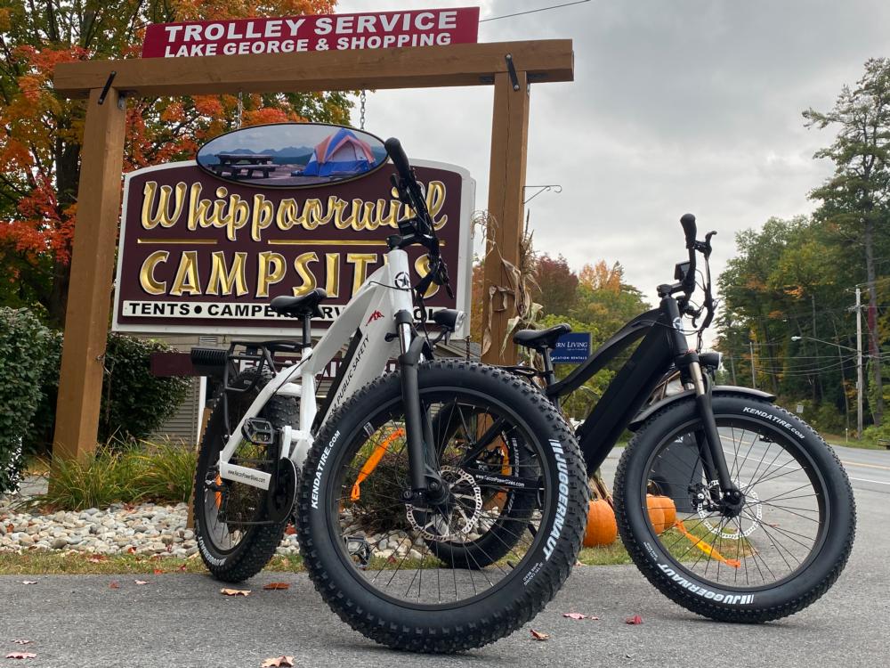 Electric bikes parked near the park sign at WHIPPOORWILL MOTEL & CAMPSITES