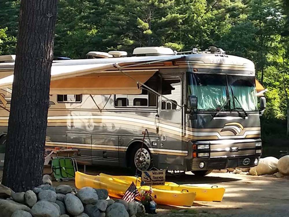 A motorhome with kayaks sitting in front at LAKE GEORGE RIVERVIEW CAMPGROUND