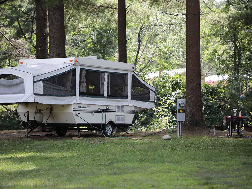 A pop up trailer in a grassy area at LAKE GEORGE RIVERVIEW CAMPGROUND