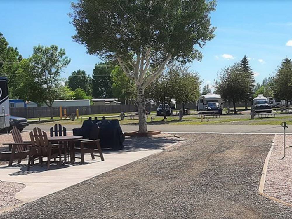 Table and chairs next to a gravel site at LARAMIE RV RESORT BY RJOURNEY