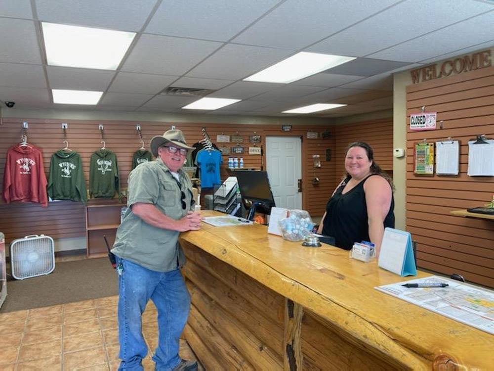 A young lady helping a man at the front desk at LARAMIE RV RESORT BY RJOURNEY