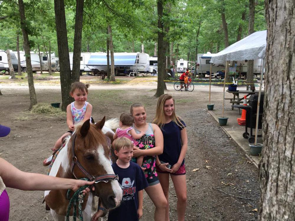 Kids posing next to a pony at TIP TAM CAMPING RESORT