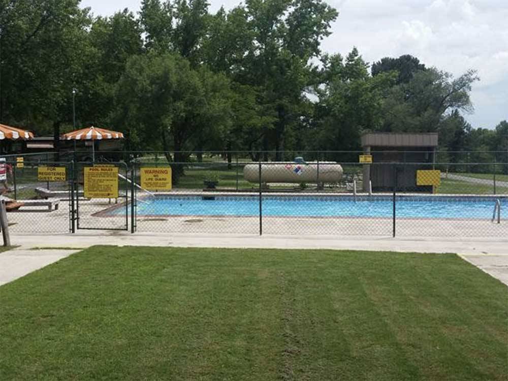 View of swimming pool with trees in the background at FORT SMITH-ALMA RV PARK