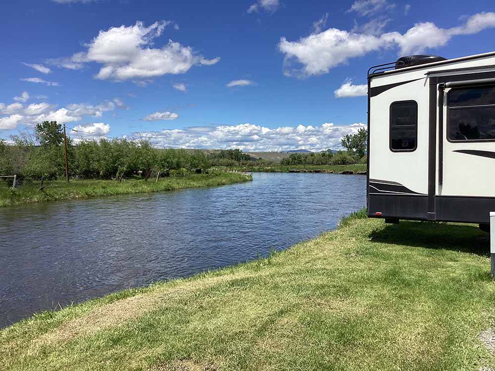 Grassy RV sites next to the river at DEER LODGE A-OK CAMPGROUND