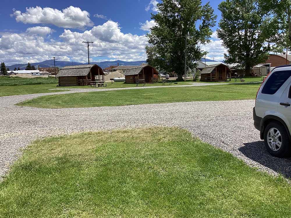 A row of rustic rental cabins at DEER LODGE A-OK CAMPGROUND