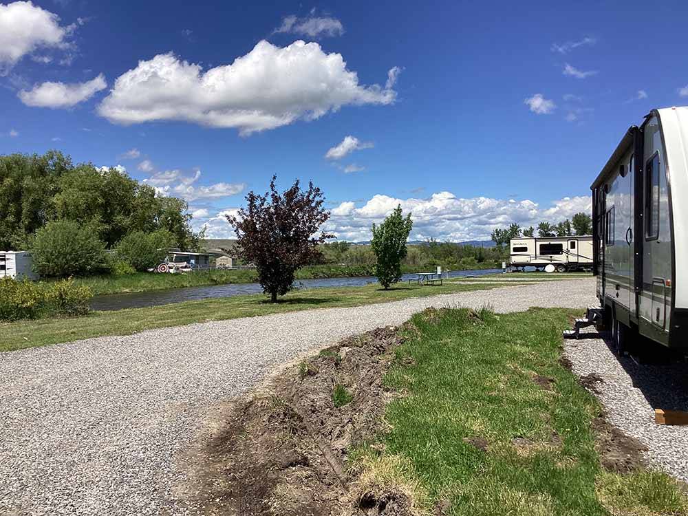 A gravel road by the river at DEER LODGE A-OK CAMPGROUND