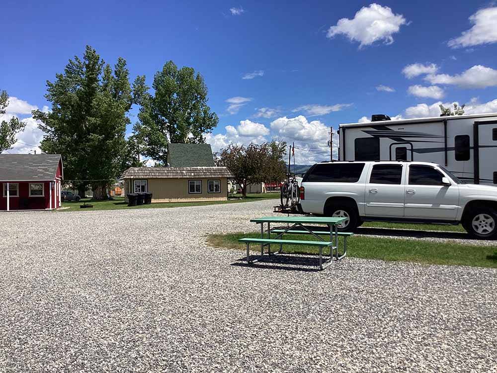 A picnic table at a gravel RV site at DEER LODGE A-OK CAMPGROUND