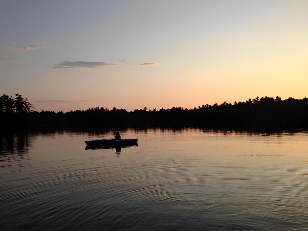 A rowboat on the water at sunset