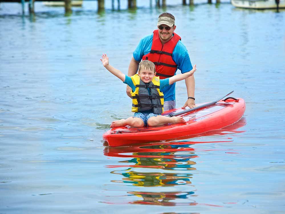 A kid on a kayak with his father at SUN OUTDOORS CAPE CHARLES