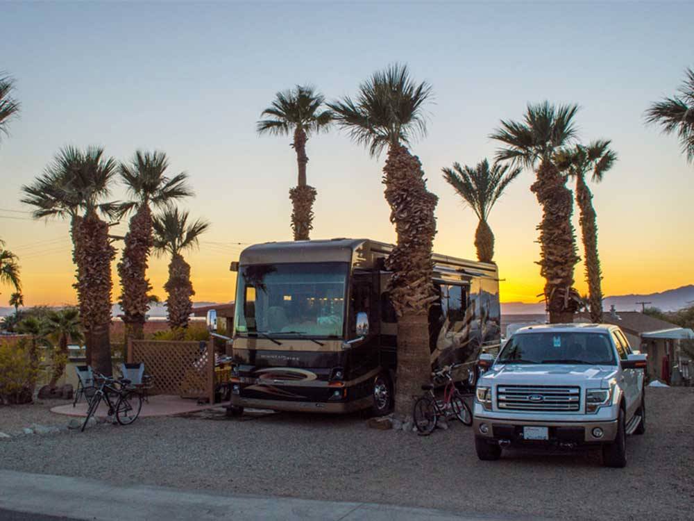 Motorhome in campsite with sunset in background at FOUNTAIN OF YOUTH SPA RV RESORT