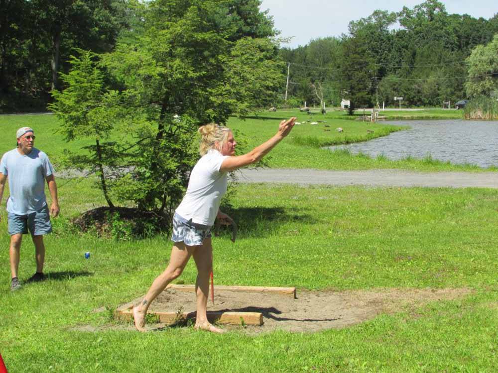 A woman playing horseshoes at RIP VAN WINKLE CAMPGROUNDS
