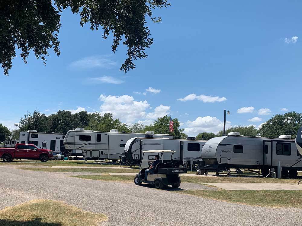 A row of travel trailers in paved sites at HATCH RV PARK